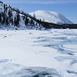 Une photo de Christophe Migeon présentant un paysage du Nunavik où une glace craquée recouvre une étendue d’eau.